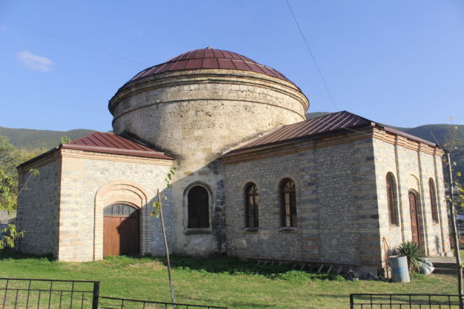 Die Nukha-Drei-Heiligen-Kirche (Aserbaidschanisch: mq?dd?s kils?si; Russisch: Nuh?????? ????????????????? ???????, romanisiert: Nukhinskaya trekhsvyatitelskaya tserkov) oder Rundtempel (Aserbaidschanisch: Dair?vi m?b?d) ist ein ehemaliges russisch-or